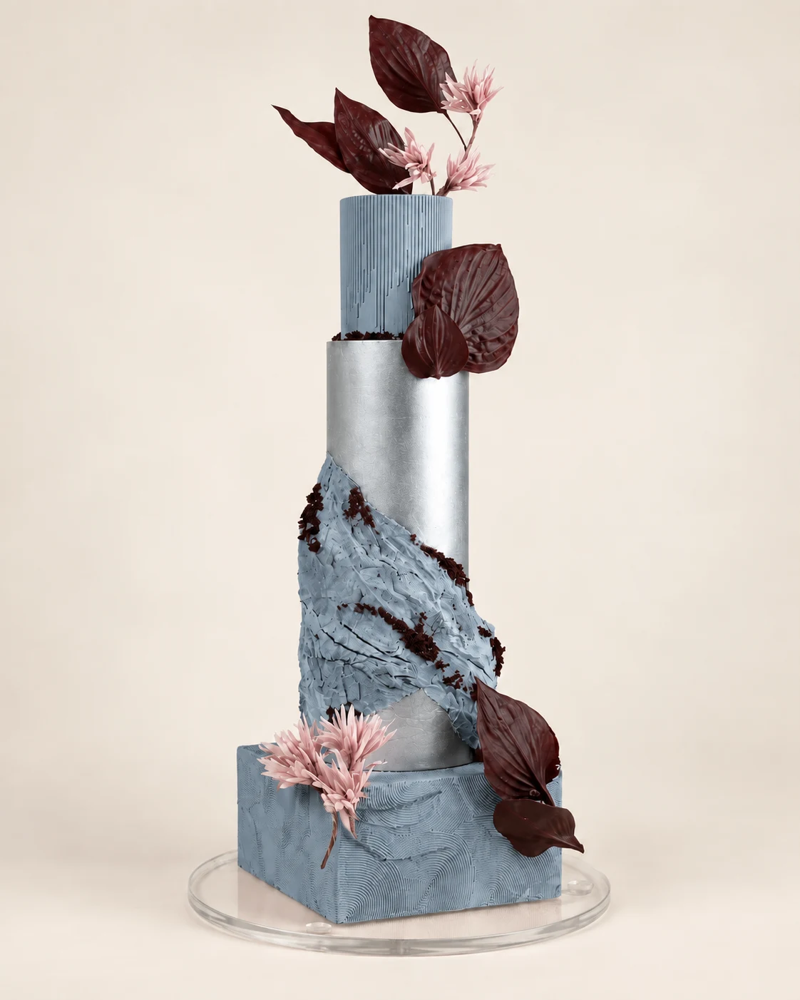 Hohe Torte in gedecktem Blau mit Schokoladenblättern